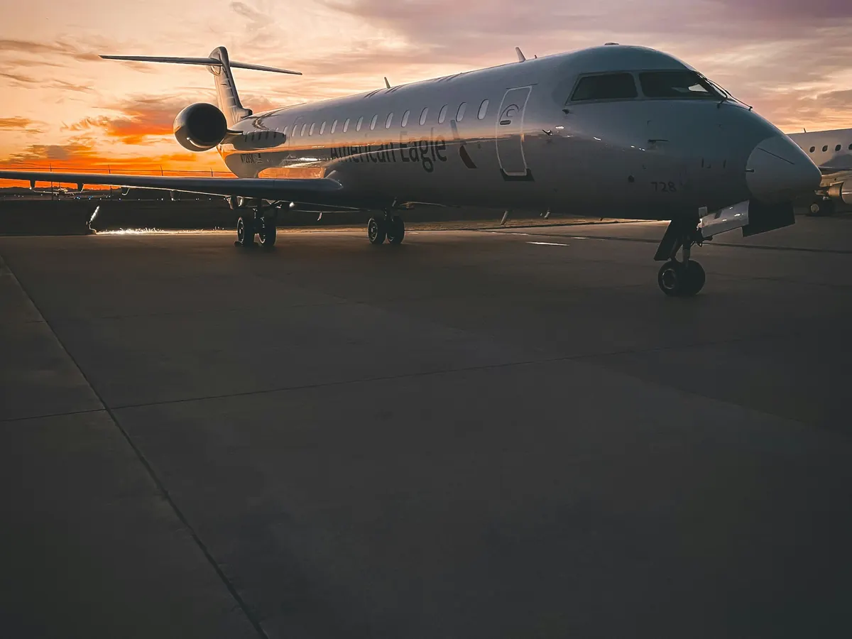 A business jet on an empty ramp under a dusk sky